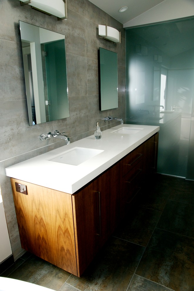 Inspiration for a mid-sized modern bathroom in Orange County with flat-panel cabinets, medium wood cabinets, grey walls, slate floors, an integrated sink, quartzite benchtops, an alcove shower, gray tile, porcelain tile, grey floor and a hinged shower door.