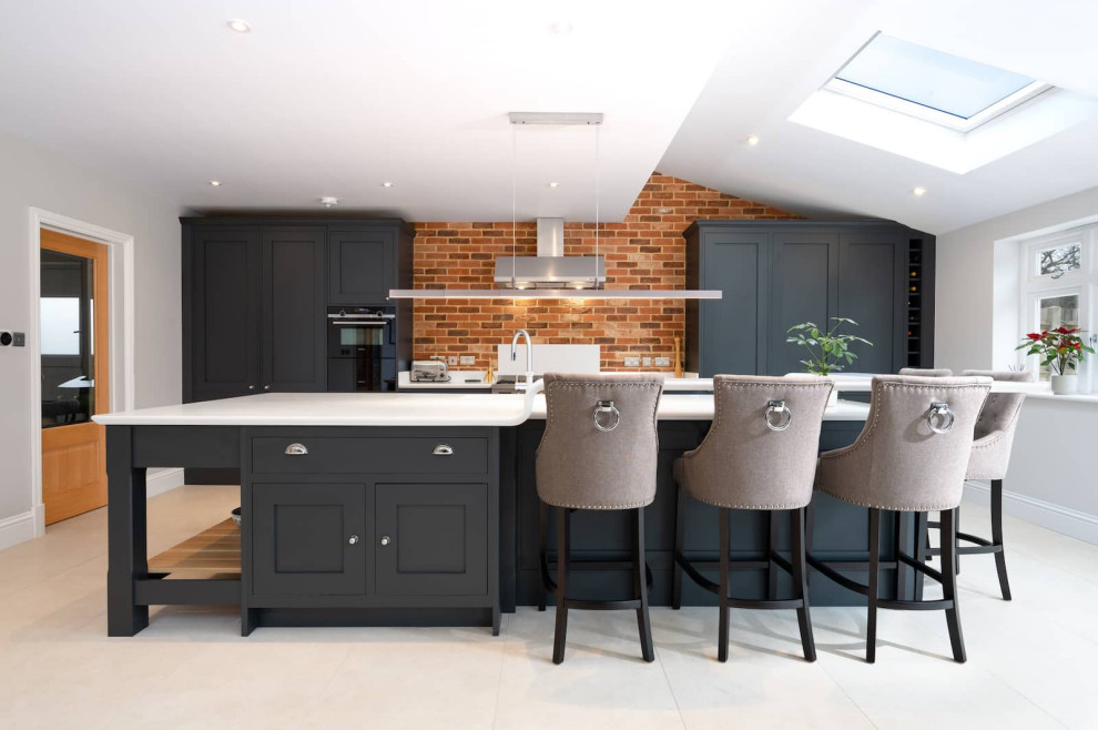 Design ideas for a large urban open plan kitchen in Hertfordshire with an integrated sink, shaker cabinets, blue cabinets, quartz worktops, brown splashback, terracotta splashback, black appliances, ceramic flooring, an island, white floors, white worktops, a drop ceiling and feature lighting.