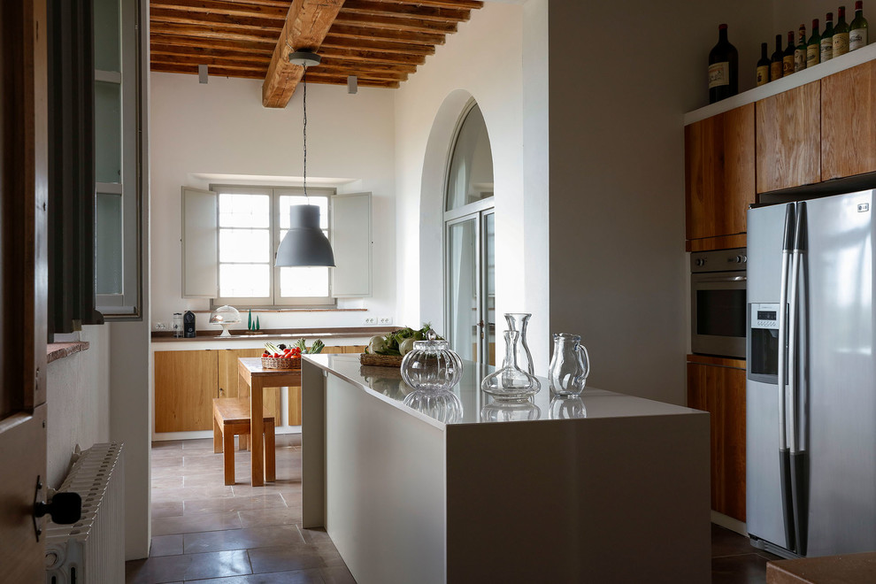Inspiration for a mediterranean l-shaped eat-in kitchen in Other with flat-panel cabinets, medium wood cabinets, with island and brown floor.