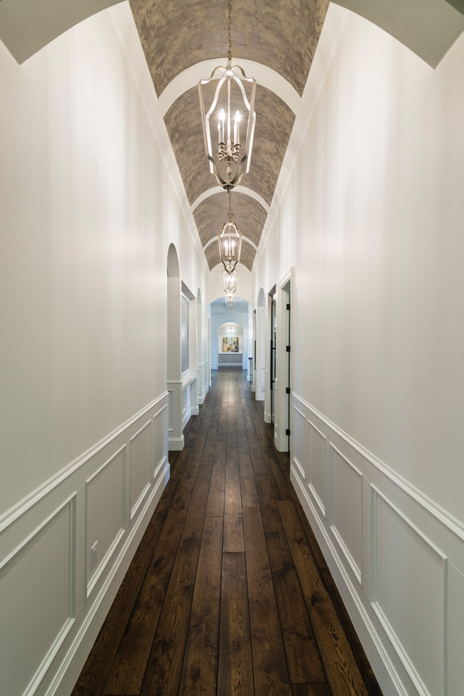Huge mountain style medium tone wood floor and brown floor hallway photo in Vancouver with white walls