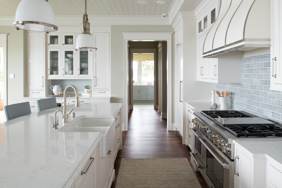 Design ideas for a large traditional u-shaped open plan kitchen in Minneapolis with a farmhouse sink, porcelain splashback, stainless steel appliances and with island.