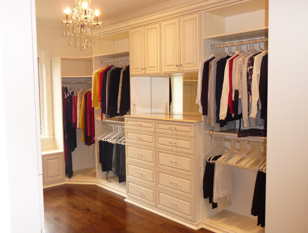 This is an example of a mid-sized traditional gender-neutral dressing room in DC Metro with flat-panel cabinets, white cabinets and medium hardwood floors.