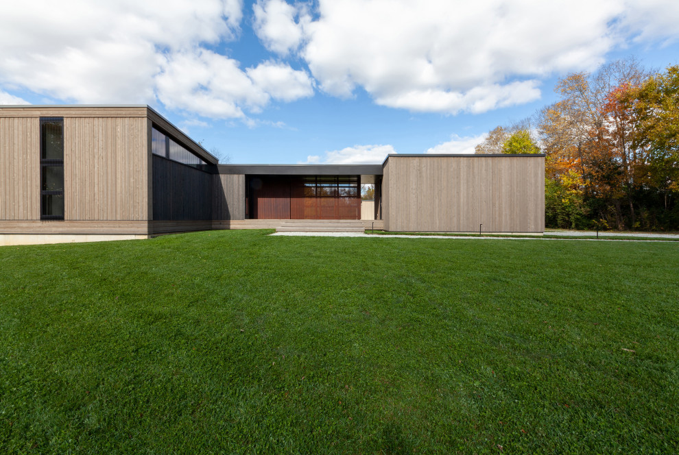 Réalisation d'une petite façade de maison grise minimaliste en bois et bardage à clin de plain-pied avec un toit en appentis, un toit en métal et un toit gris.