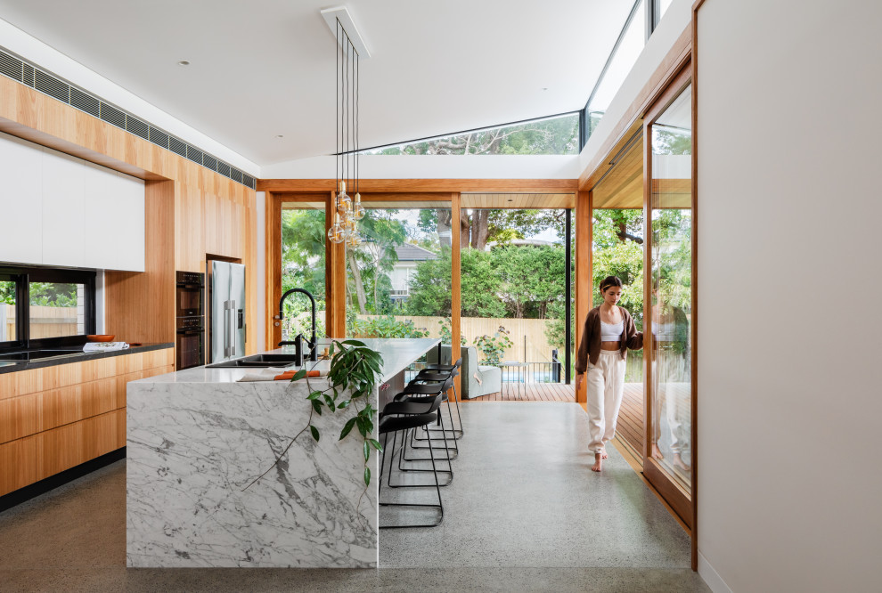 Moderne Wohnküche mit Marmor-Arbeitsplatte, Betonboden und Kücheninsel in Sydney