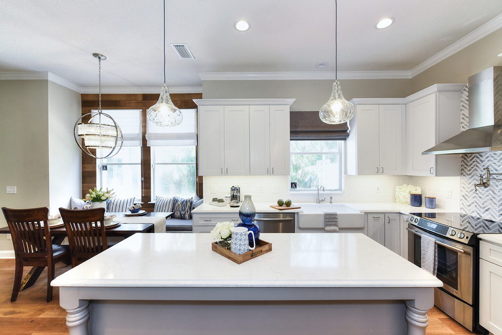 Example of a large transitional l-shaped medium tone wood floor eat-in kitchen design in Jacksonville with a farmhouse sink, shaker cabinets, quartz countertops and an island