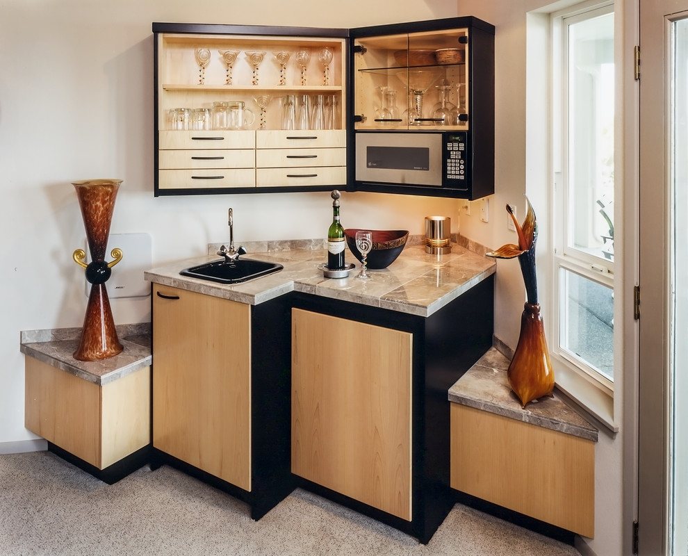 This is an example of a contemporary single-wall wet bar in Seattle with an undermount sink, flat-panel cabinets and light wood cabinets.