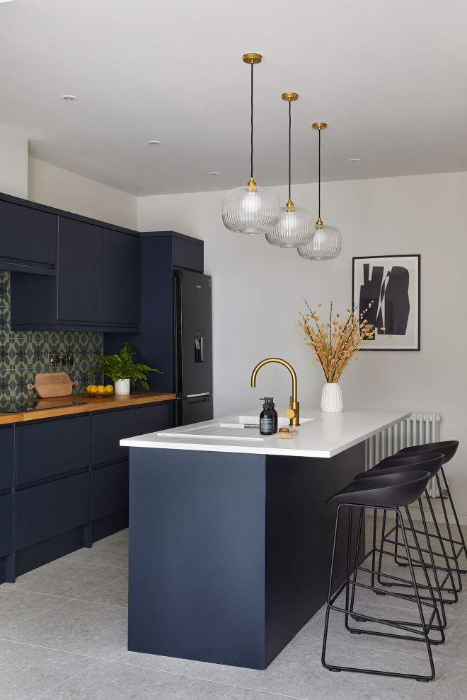 Medium sized contemporary galley kitchen/diner in Other with a double-bowl sink, flat-panel cabinets, blue cabinets, composite countertops, green splashback, ceramic splashback, stainless steel appliances, porcelain flooring, an island, white floors, multicoloured worktops and feature lighting.
