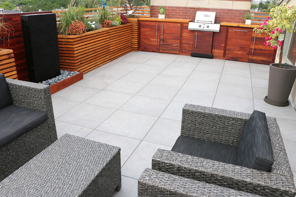 Small contemporary patio in Chicago with a water feature and natural stone pavers.