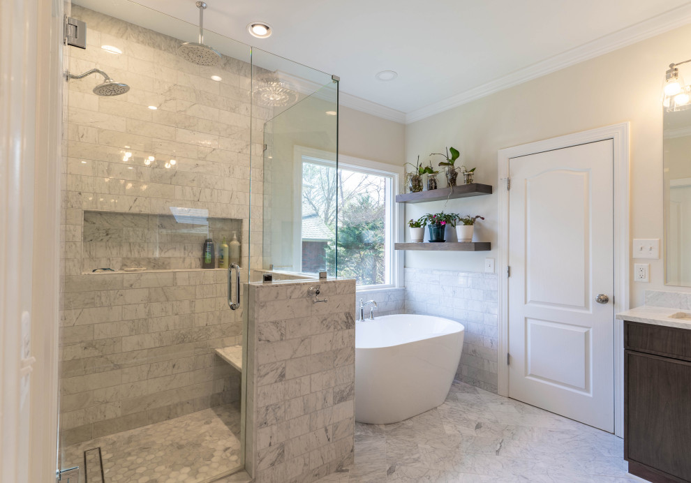 This is an example of a large master bathroom in Charlotte with recessed-panel cabinets, white cabinets, a freestanding tub, an alcove shower, a one-piece toilet, beige walls, a drop-in sink, a hinged shower door, grey benchtops, a shower seat, a double vanity and a built-in vanity.