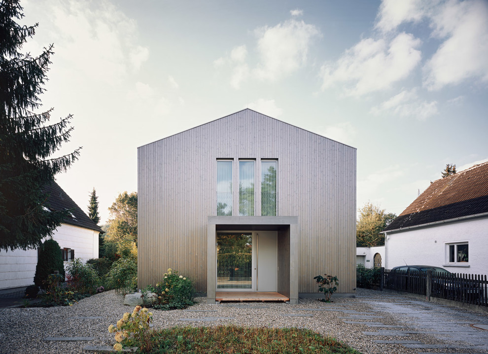 This is an example of a mid-sized contemporary two-storey brown exterior in Munich with wood siding and a gable roof.
