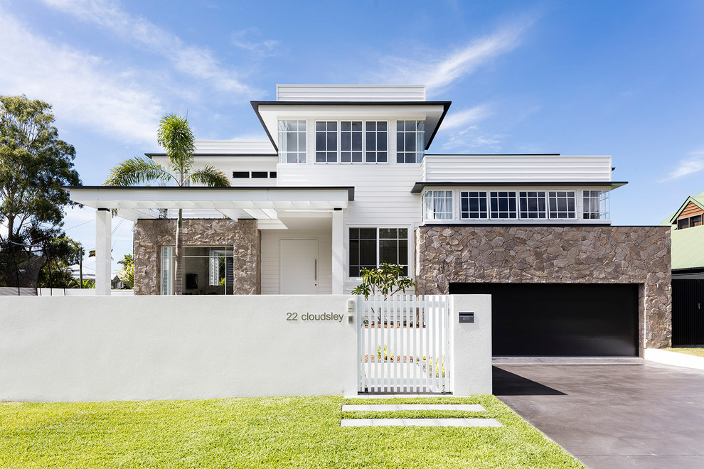 Photo of a beach style two-storey white house exterior in Sunshine Coast.
