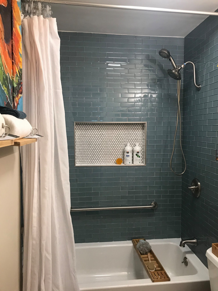 Photo of a bathroom in Atlanta with open cabinets, white cabinets, an alcove bath, a shower/bath combination, a two-piece toilet, blue tiles, beige walls, a built-in sink, white floors, a shower curtain, white worktops, a single sink and a floating vanity unit.