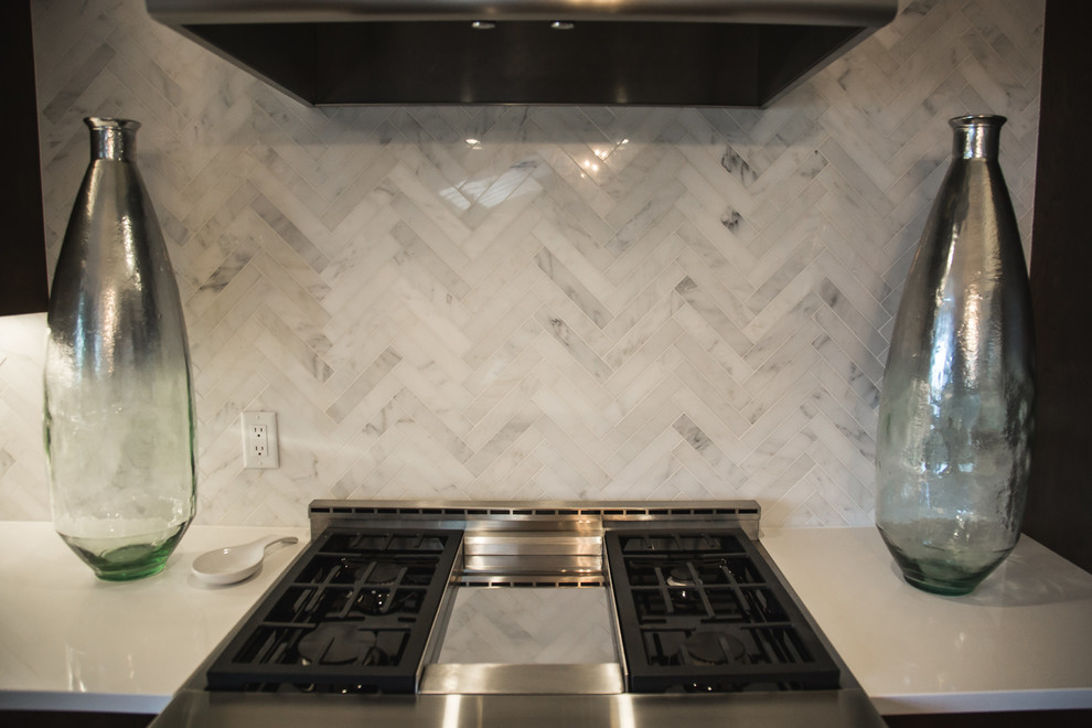 Inspiration for a transitional brown floor and medium tone wood floor kitchen remodel with recessed-panel cabinets, dark wood cabinets, white backsplash, stainless steel appliances and marble backsplash