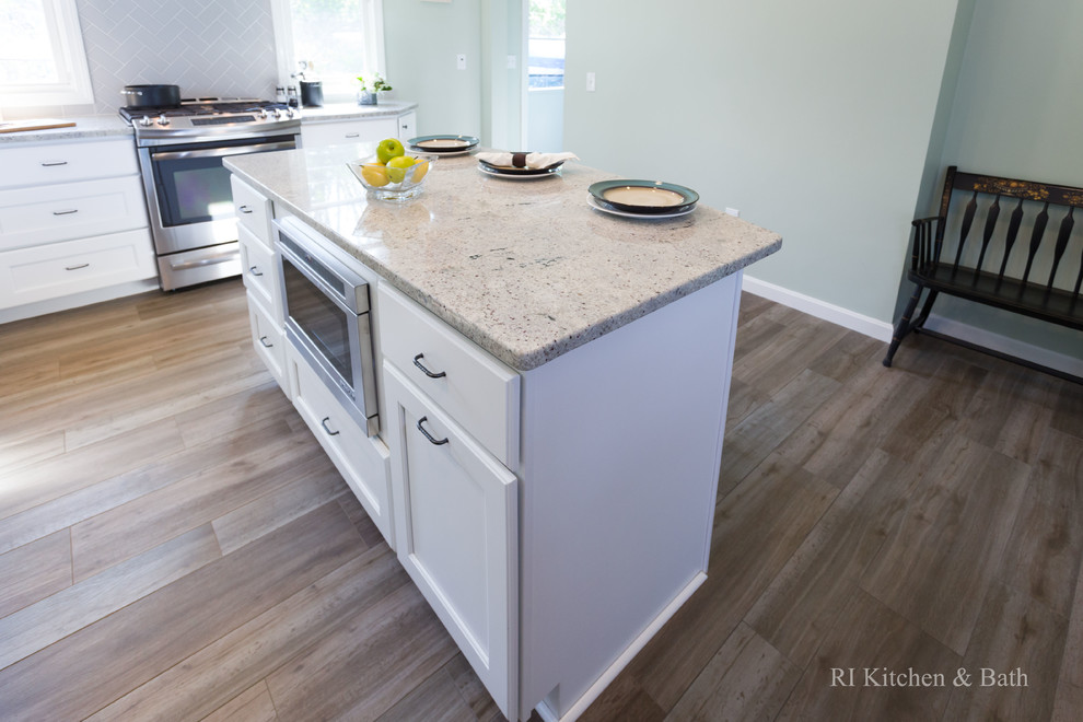 Example of a large transitional l-shaped porcelain tile eat-in kitchen design in Providence with an undermount sink, recessed-panel cabinets, white cabinets, granite countertops, gray backsplash, ceramic backsplash, stainless steel appliances, green walls and an island