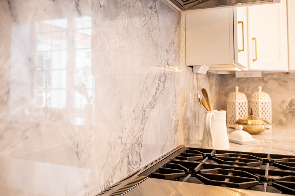 Inspiration for a large transitional dark wood floor and brown floor eat-in kitchen remodel in Baltimore with an undermount sink, shaker cabinets, white cabinets, marble countertops, white backsplash, marble backsplash, stainless steel appliances, an island and gray countertops