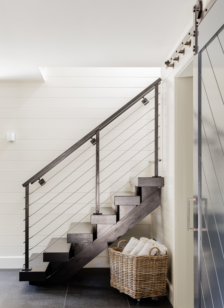 This is an example of a mid-sized contemporary wood straight staircase in Boston with wood risers and cable railing.