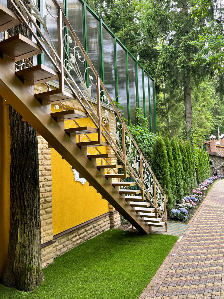На фото: прямая лестница среднего размера в восточном стиле с ступенями из плитки, металлическими перилами и кирпичными стенами