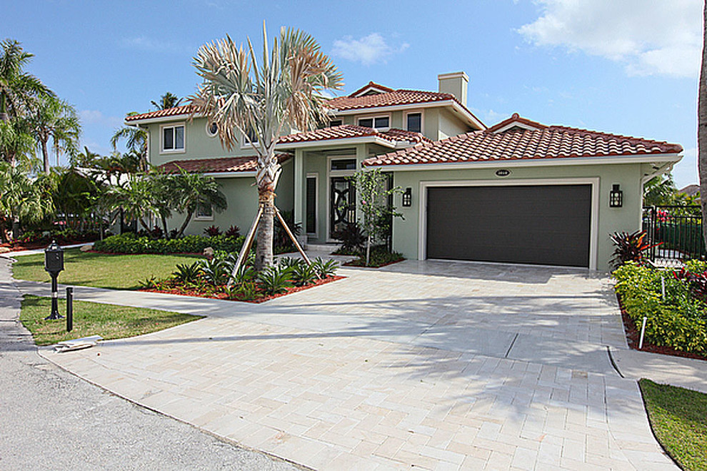 Photo of a large beach style two-storey green exterior in Miami.