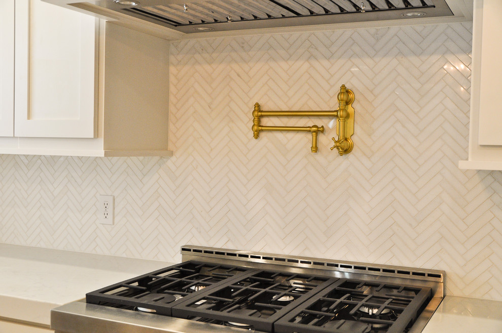 Mid-sized transitional kitchen photo in New Orleans with shaker cabinets, white cabinets, quartz countertops, white backsplash, marble backsplash, stainless steel appliances and white countertops