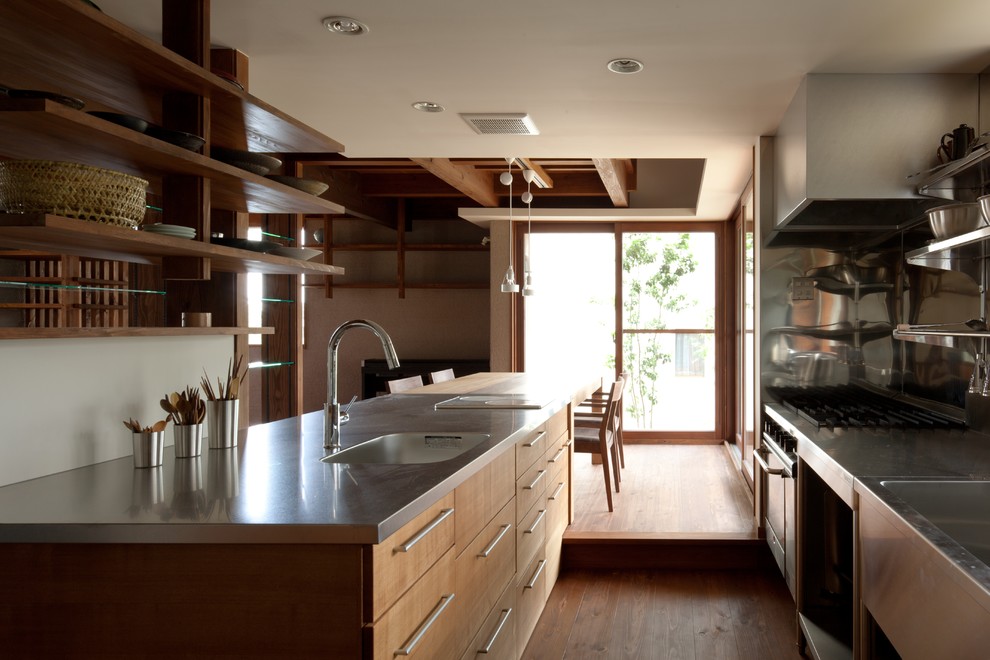 Design ideas for an asian kitchen in Other with light wood cabinets, stainless steel benchtops, a single-bowl sink, medium hardwood floors and brown floor.