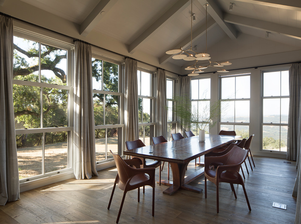 Photo of a country dining room in San Francisco with grey walls, medium hardwood floors and brown floor.