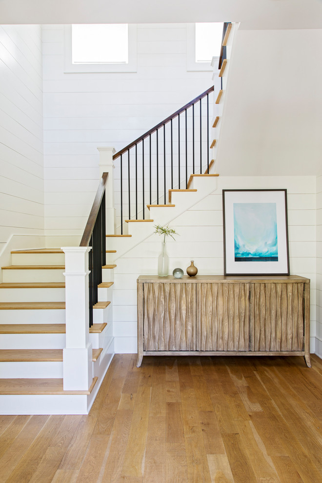 Beach style wood staircase in Charleston with painted wood risers and wood railing.