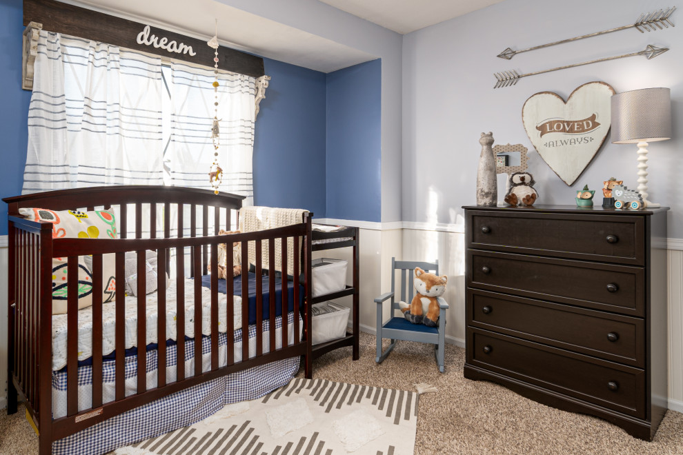 This is an example of a mid-sized transitional nursery for boys in Grand Rapids with blue walls, carpet, beige floor and decorative wall panelling.