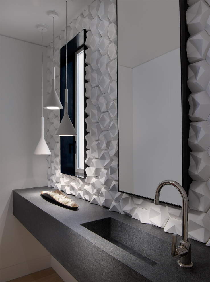 This is an example of an expansive contemporary powder room in San Francisco with white tile, white walls, an integrated sink, grey benchtops, a two-piece toilet, concrete benchtops, medium hardwood floors and brown floor.