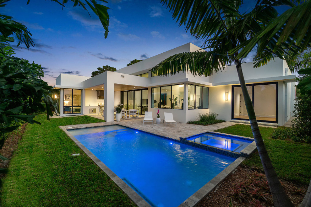 Photo of a mid-sized contemporary backyard rectangular pool in Miami with a hot tub and tile.