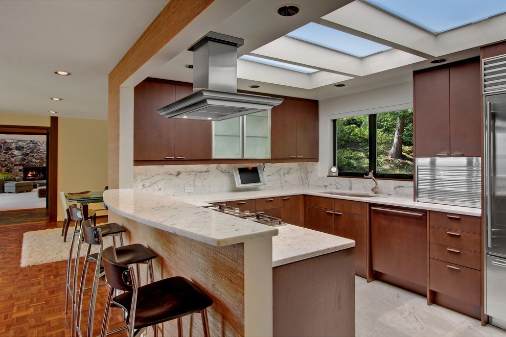 Midcentury eat-in kitchen in Seattle with an undermount sink, flat-panel cabinets, medium wood cabinets, marble benchtops, stainless steel appliances and marble floors.