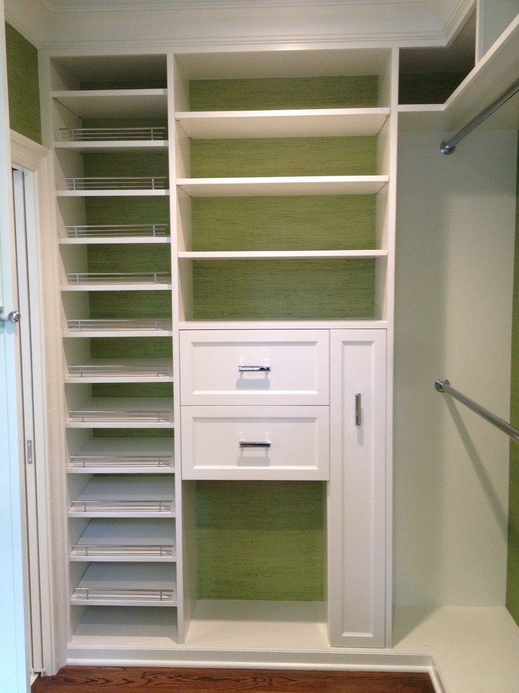 Photo of a mid-sized contemporary gender-neutral walk-in wardrobe in Chicago with recessed-panel cabinets, white cabinets, dark hardwood floors and brown floor.