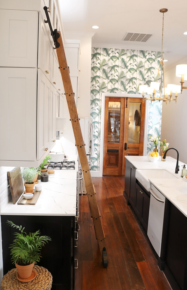 Mid-sized transitional single-wall separate kitchen in Providence with a farmhouse sink, recessed-panel cabinets, black cabinets, quartzite benchtops, white splashback, subway tile splashback, white appliances, dark hardwood floors, with island, brown floor and white benchtop.