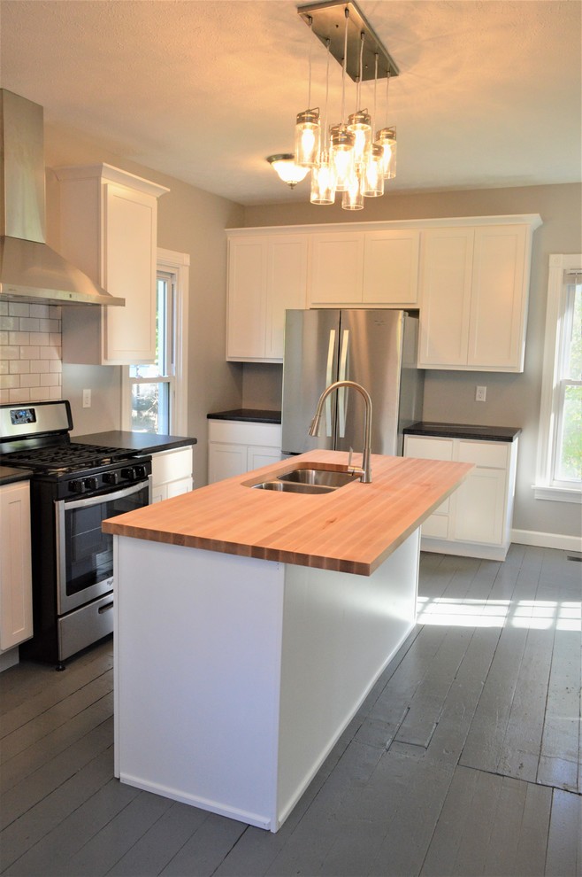 This is an example of a large modern single-wall eat-in kitchen in Other with an undermount sink, shaker cabinets, white cabinets, laminate benchtops, with island, grey floor, black benchtop and painted wood floors.