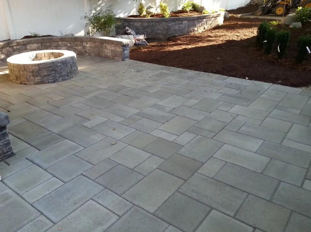 Photo of a mid-sized transitional backyard patio in Bridgeport with a fire feature, concrete pavers and no cover.
