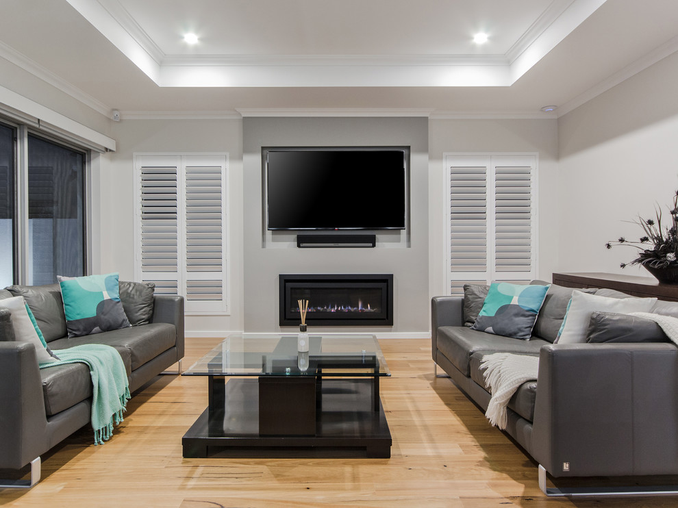This is an example of a contemporary formal enclosed living room in Perth with grey walls, light hardwood floors, a ribbon fireplace, a wall-mounted tv and beige floor.