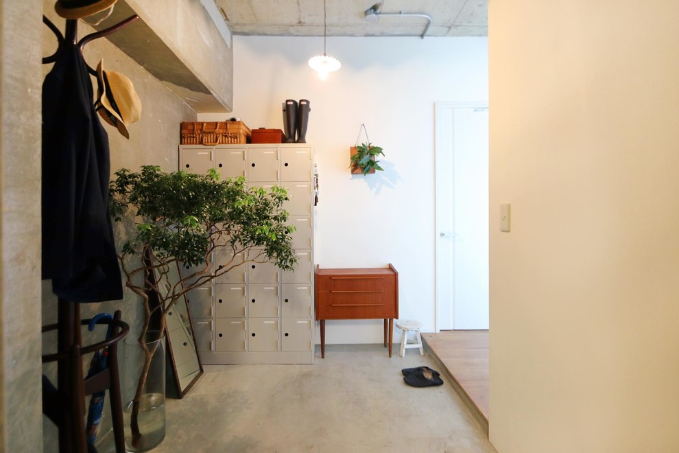 This is an example of a country entryway in Tokyo with multi-coloured walls, concrete floors and grey floor.