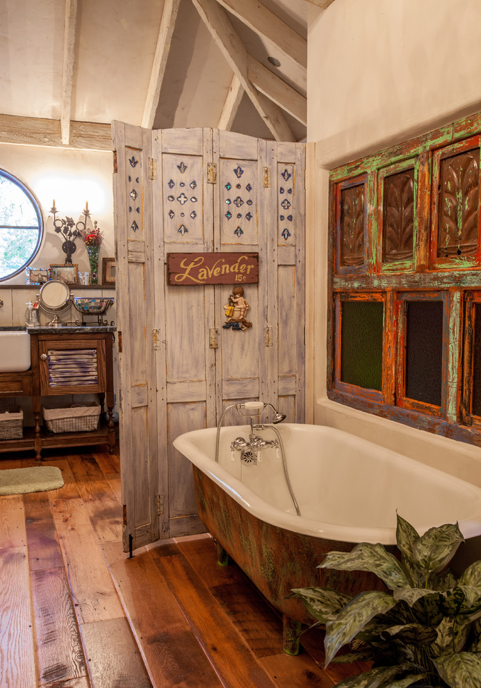 Photo of a traditional bathroom in Dallas with distressed cabinets, a freestanding tub and louvered cabinets.