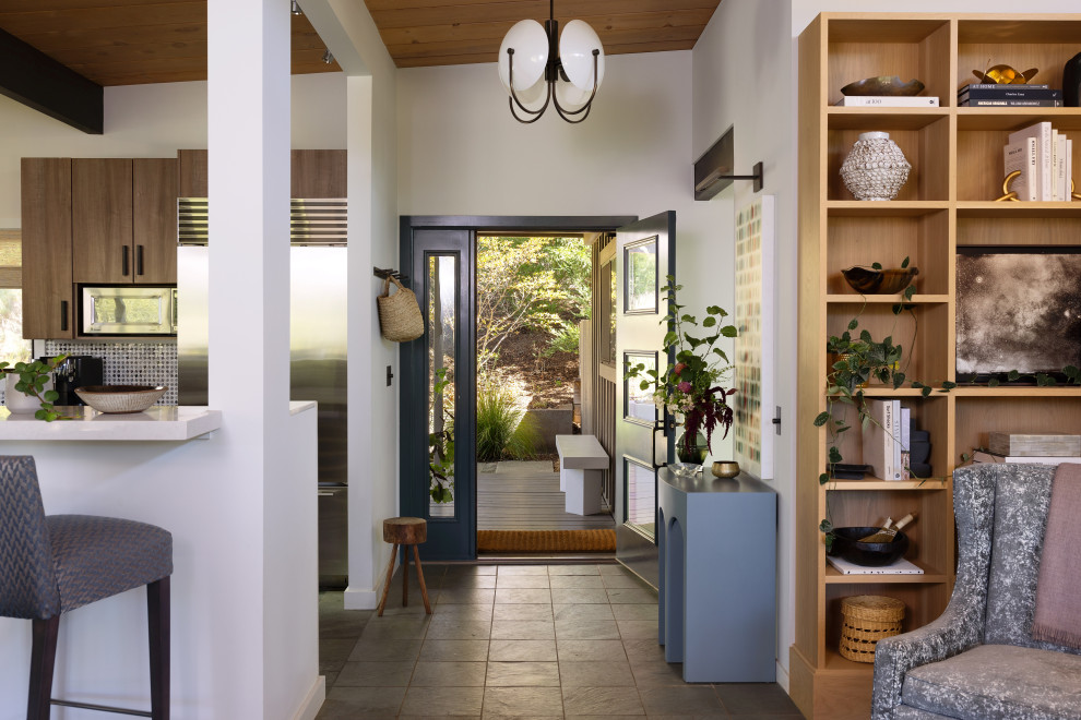 Photo of a mid-sized midcentury front door in San Francisco with white walls, slate floors, a single front door, a black front door, green floor and exposed beam.