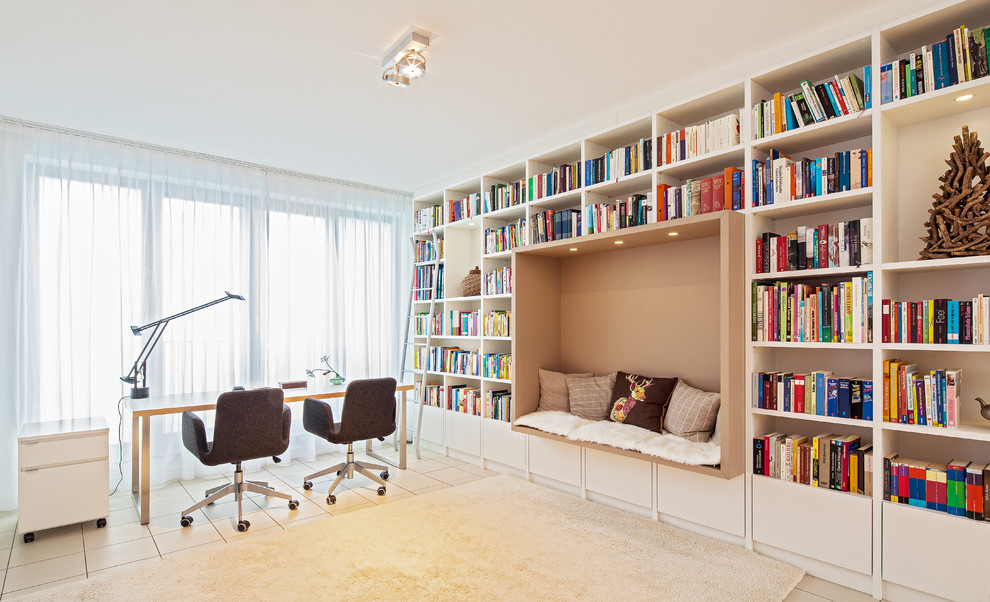 This is an example of a large contemporary study room in Frankfurt with white walls, a freestanding desk, no fireplace and ceramic floors.