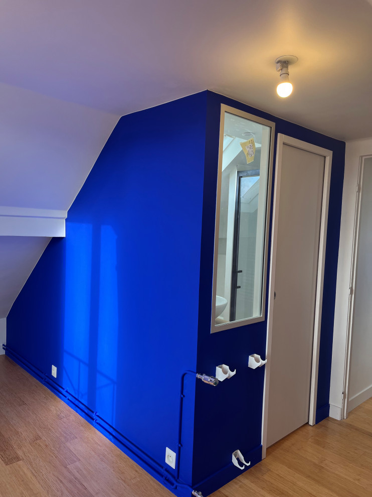 Idée de décoration pour un petit bureau design avec un mur bleu et parquet en bambou.