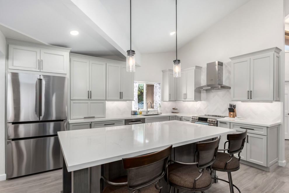 Eat-in kitchen - mid-sized transitional porcelain tile and gray floor eat-in kitchen idea in Phoenix with an undermount sink, shaker cabinets, gray cabinets, quartz countertops, white backsplash, subway tile backsplash, stainless steel appliances, an island and white countertops