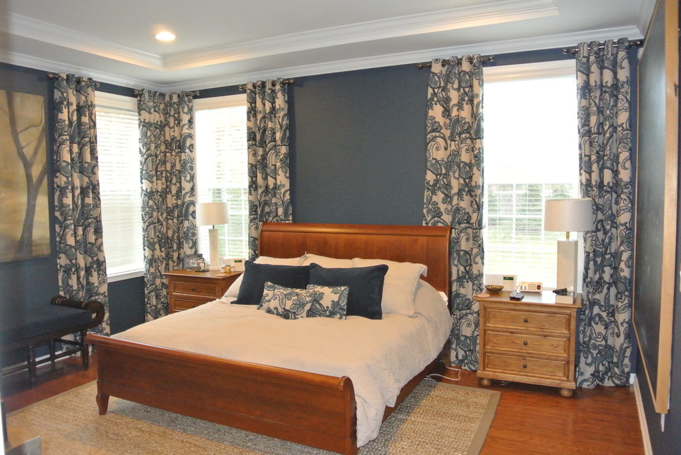 This is an example of a mid-sized traditional master bedroom in New York with blue walls, medium hardwood floors, no fireplace and brown floor.