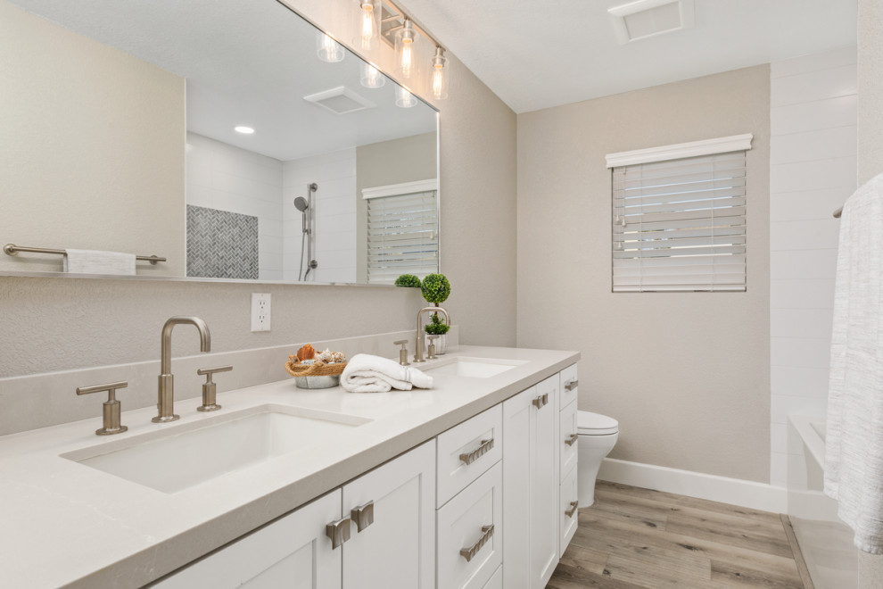 Inspiration for a small modern bathroom in San Diego with shaker cabinets, white cabinets, a built-in bath, a shower/bath combination, a one-piece toilet, grey walls, vinyl flooring, a submerged sink, engineered stone worktops, grey floors, a shower curtain, grey worktops, double sinks and a built in vanity unit.