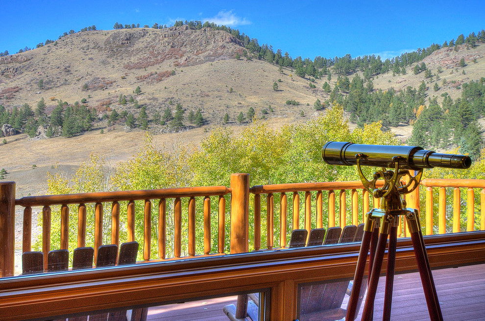 Inspiration for a large rustic backyard deck remodel in Denver with a roof extension