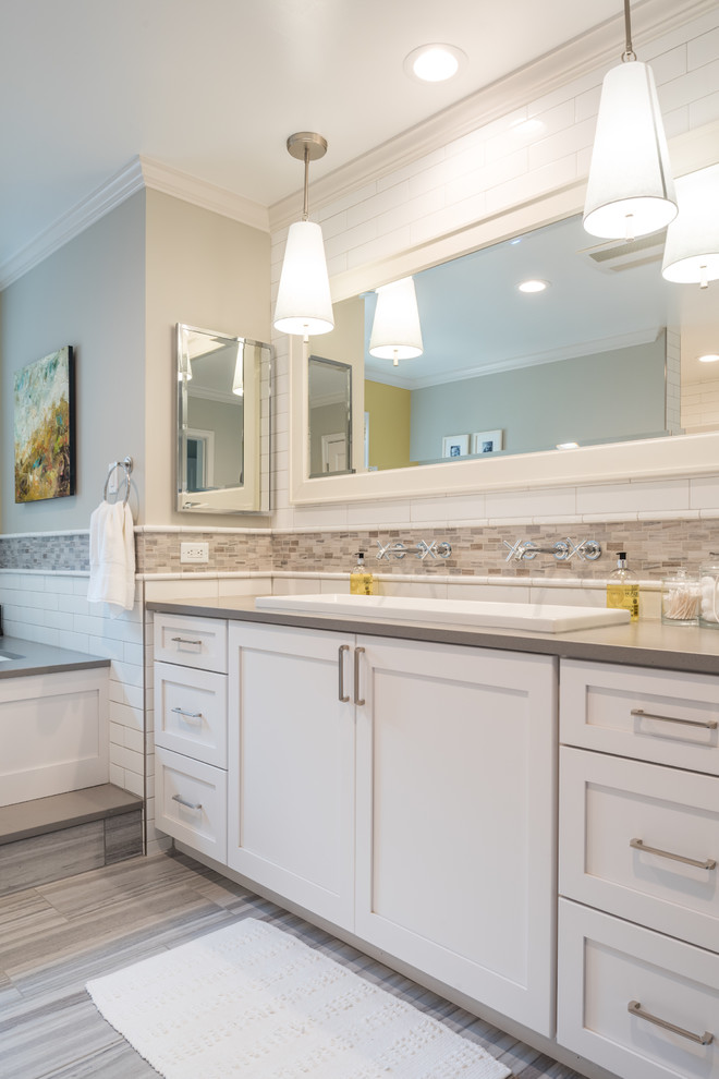 Inspiration for a mid-sized traditional master bathroom in St Louis with shaker cabinets, white cabinets, a hot tub, a double shower, a two-piece toilet, white tile, subway tile, grey walls, ceramic floors, a trough sink, engineered quartz benchtops, grey floor and a hinged shower door.