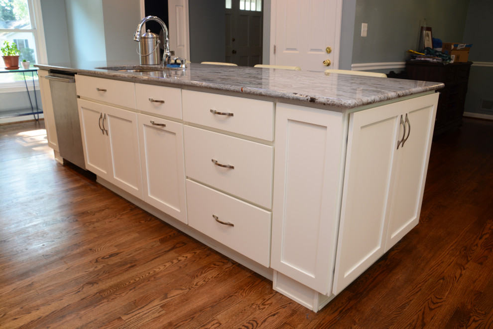 This is an example of a large traditional l-shaped separate kitchen in Baltimore with an undermount sink, recessed-panel cabinets, white cabinets, granite benchtops, blue splashback, stainless steel appliances, dark hardwood floors, with island, brown floor and blue benchtop.