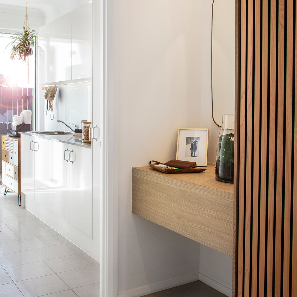 Inspiration for a mid-sized midcentury foyer in Canberra - Queanbeyan with white walls, concrete floors, a pivot front door, an orange front door and white floor.