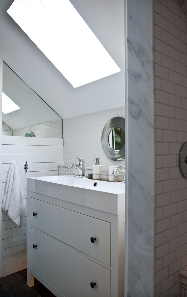 Alcove shower - mid-sized transitional kids' white tile and porcelain tile limestone floor alcove shower idea in Boston with a trough sink, furniture-like cabinets, white cabinets, quartz countertops, a one-piece toilet and white walls