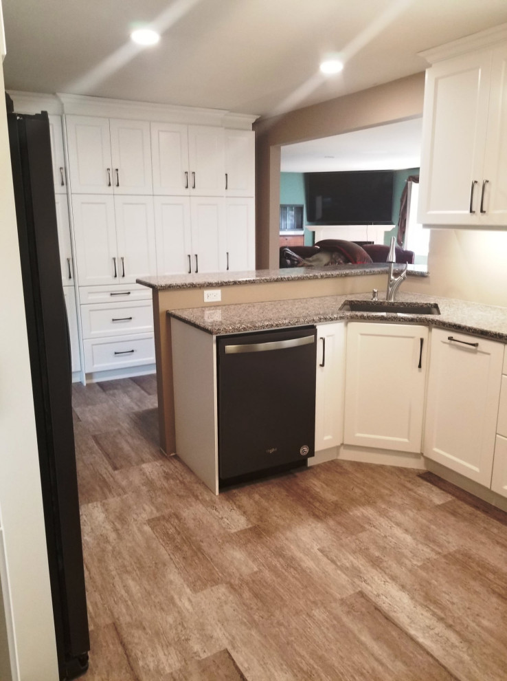 Inspiration for a mid-sized transitional u-shaped gray floor eat-in kitchen remodel with an undermount sink, recessed-panel cabinets, white cabinets, granite countertops, black appliances and a peninsula