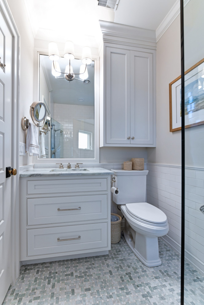 Small traditional bathroom in Charleston with beaded inset cabinets, white cabinets, a two-piece toilet, white tile, ceramic tile, marble floors, an undermount sink, marble benchtops, grey floor, a hinged shower door, blue benchtops, a single vanity and a built-in vanity.